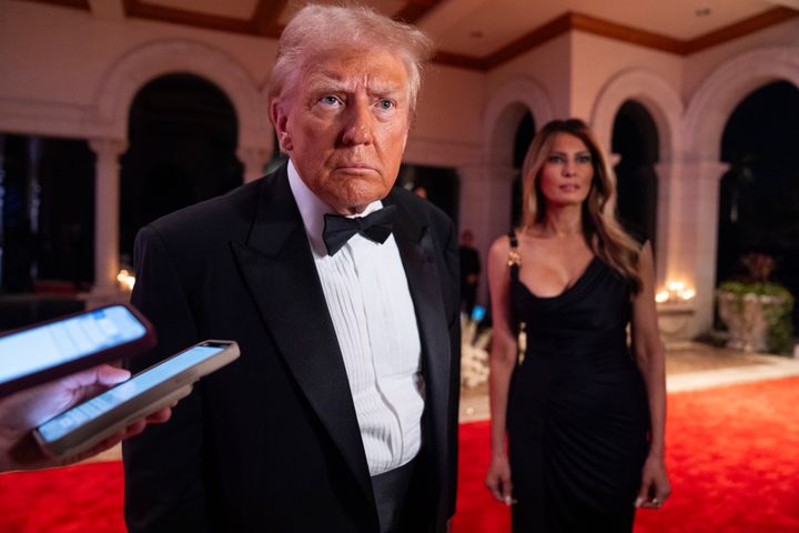 Melania Trump looks on as President-elect Donald Trump speaks to reporters before a New Year's Eve party at Mar-a-Lago.