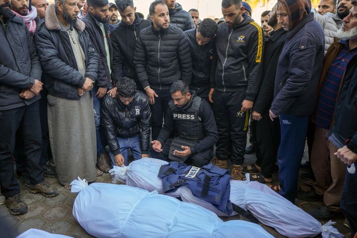 Colleagues and friends mourn over the body of freelance journalist Omar al-Derawi and other victims of overnight Israeli army strikes at multiple locations in central Gaza Strip, at Al-Aqsa Martyrs Hospital in Deir al-Balah, Friday, Jan. 3, 2025. (AP Photo/Abdel Kareem Hana)