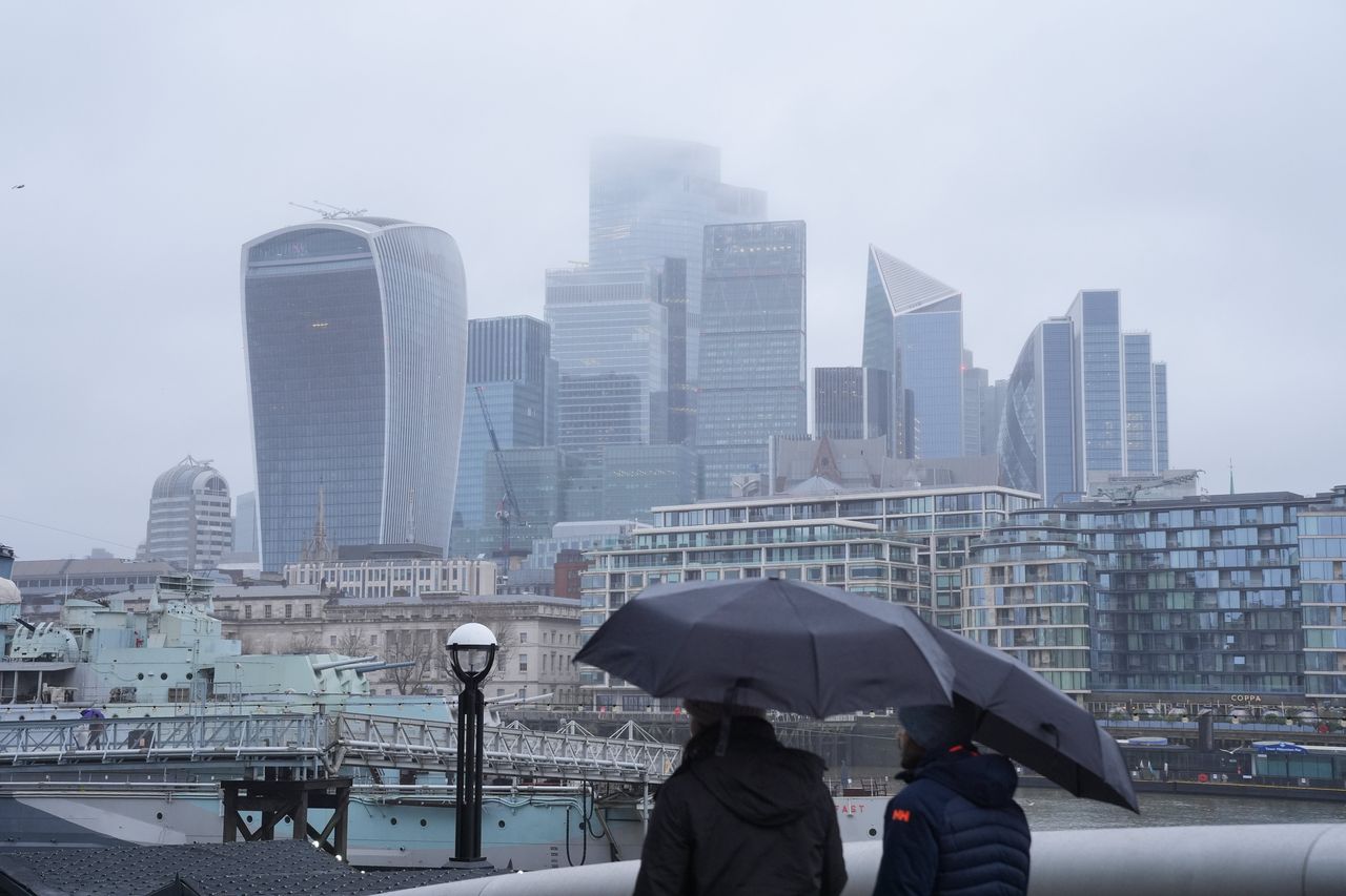 Άνθρωποι κατά τη διάρκεια μιας βροχής στο More London στη νότια όχθη του ποταμού Τάμεση κοντά στη γέφυρα Tower Bridge, στο Λονδίνο, καθώς εκδόθηκε νέα κίτρινη προειδοποίηση για βροχή στη νότια Αγγλία την Κυριακή. Αλλού, το βαρύ χιόνι κατά τη διάρκεια της νύχτας προκαλεί αναστάτωση σε τμήματα του Ηνωμένου Βασιλείου, καθώς συνεχίζεται το κρύο ξεκίνημα του νέου έτους. Ημερομηνία εικόνας: Κυριακή 5 Ιανουαρίου 2025. (Φωτογραφία: Yui Mok/PA Images via Getty Images)