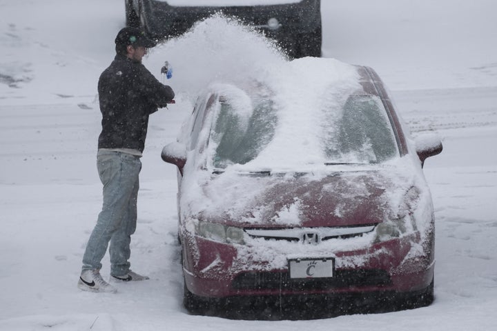 A person dusts snow off of a car during a winter storm on Jan. 5, 2025, in Cincinnati.