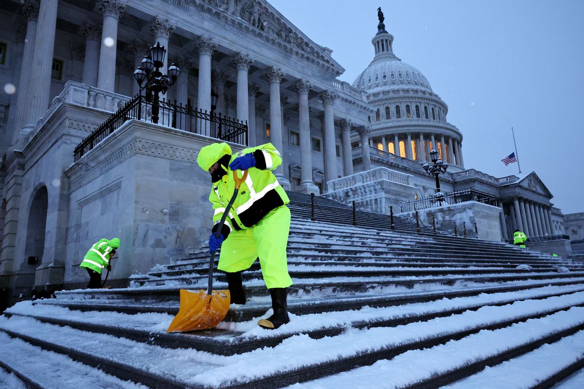 Crews work before dawn to clear snow from the steps on the East Front of the U.S. Capitol as a winter storm slams into the nation's capital on January 06, 2025 in Washington, DC.