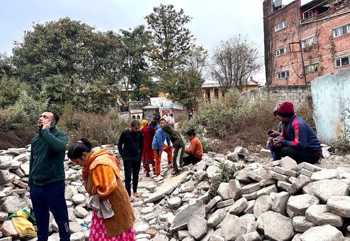 Nepalese people who rushed out of their homes after experiencing an earthquake stand amidst construction material in Kathmandu, Nepal, Tuesday, Jan.7, 2025. (AP Photo/Sunil Sharma)