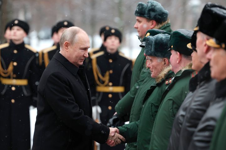 Russian President Vladimir Putin shakes hands with Russian Army veterans