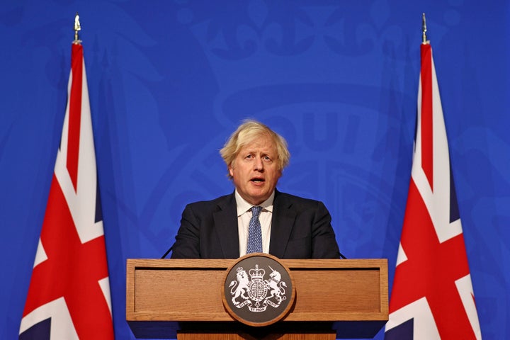 Boris Johnson giving a press conference in front of the old blue backdrop.