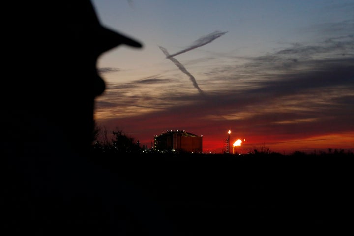 A neighbor watches flames flare from the Venture Global LNG's Calcasieu Pass liquefied natural gas export facility next to his oceanside property in Cameron, La., on Friday, April 1, 2022. 