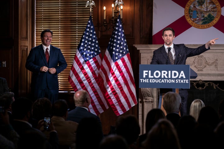 Florida Gov. Ron DeSantis listens to activist and New College of Florida trustee Christopher Rufo before signing three education bills on the campus of New College of Florida in Sarasota, Fla. on Monday, May 15, 2023. 