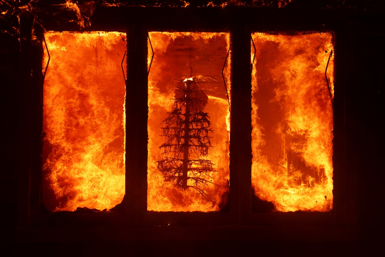 The Palisades Fire burns a Christmas tree inside a residence Tuesday.