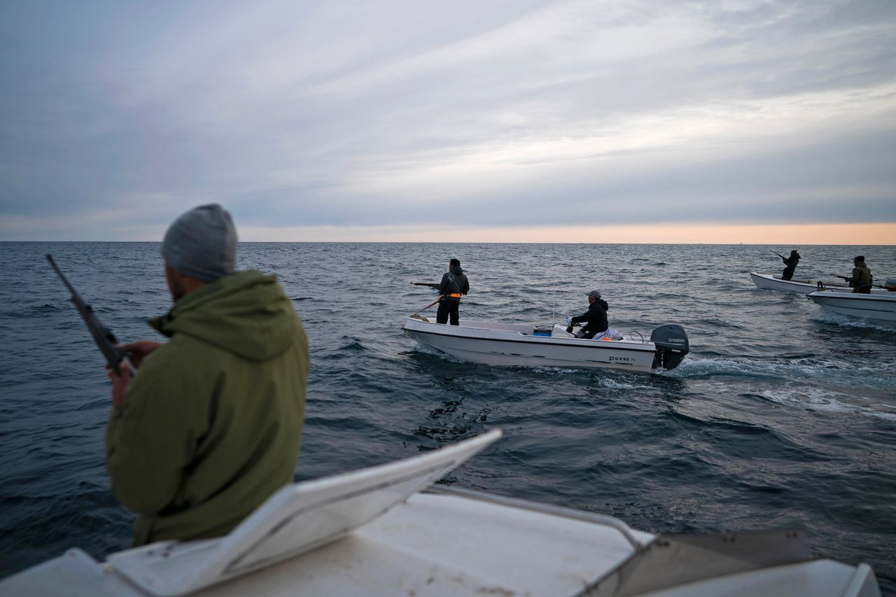 Σε αυτή τη φωτογραφία της 16ης Αυγούστου 2019, ο Mugu Utuaq, αριστερά, γεμίζει το τουφέκι του καθώς ταξιδεύει με άλλες βάρκες που κυνηγούν φάλαινες κοντά στο Kulusuk της Γροιλανδίας. (AP Photo/Felipe Dana)