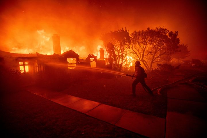 A firefighter battles the Palisades Fire as it burns a structure in the Pacific Palisades neighborhood of Los Angeles, Tuesday, Jan. 7, 2025.