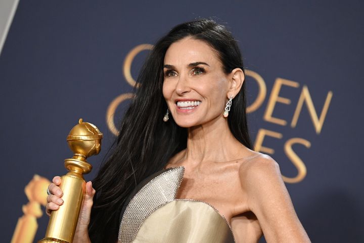 Demi Moore holds up her Golden Globe award after winning for her performance in "The Substance."