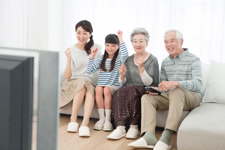 Three generations of family watching TV