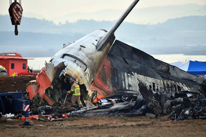 A member of the South Korean rescue team works at the site of an airplane crash at the Muan International Airport, in South Korea, on Dec. 30, 2024. The Jeju Air flight 7C2216 crashed while landing at Muan International Airport, about 290 km southwest of Seoul, on Dec. 29, 2024. All the 179 people aboard the passenger jet were confirmed dead except only two rescued. (Photo by Jun Hyosang/Xinhua via Getty Images)