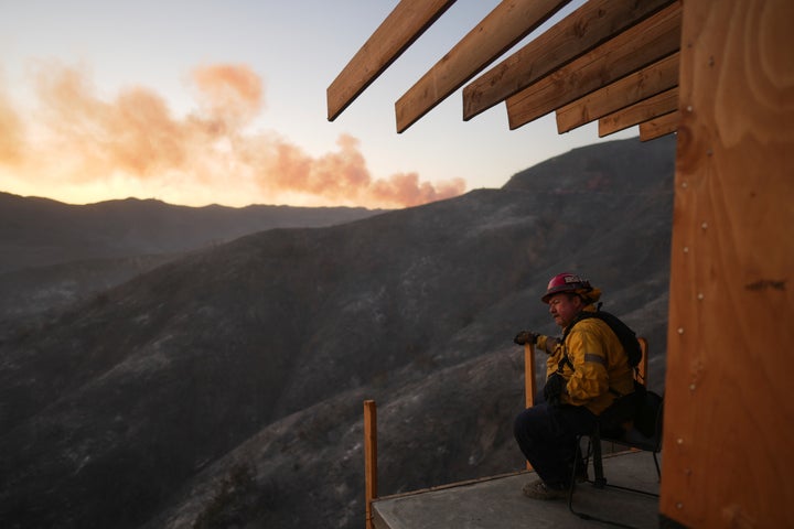 A firefighter rests as crews battle the Palisades Fire in Mandeville Canyon, Saturday, Jan. 11, 2025, in Los Angeles. (AP Photo/Eric Thayer)