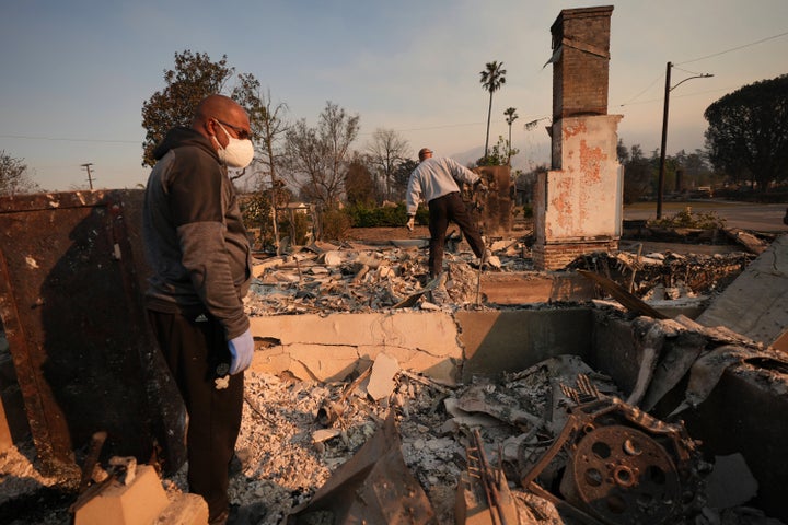 Kenneth Snowden (L) surveys the damage to his fire-ravaged property with his brother Ronnie in the aftermath of the Eaton Fire on Friday, Jan. 10, 2025 in Altadena, Calif.