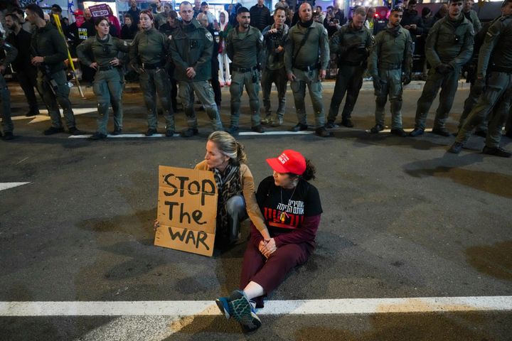 Demonstrators sit on the road and hold a sign during a protest demanding a cease-fire deal and the immediate release of hostages held in the Gaza Strip by Hamas, in Tel Aviv, Israel, on Jan. 11, 2025.