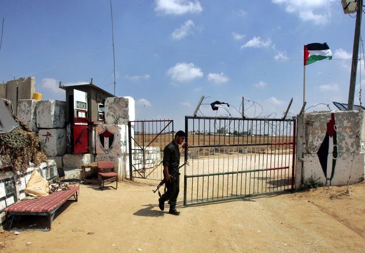 A Palestinian security officer opens a gate to the Philadelphi corridor between Egypt and Gaza near the town of Rafah, on July, 1, 2007.