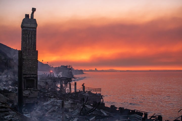 Wildfire smoke and burned houses from the Palisades Fire are seen at dawn on Jan. 10, 2025, in the Pacific Palisades neighborhood of Los Angeles.