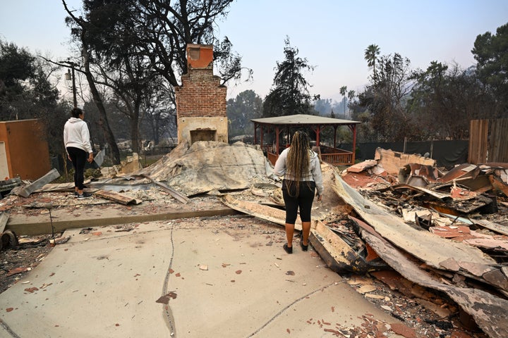 Two people inspect the rubble of a home destroyed in the Eaton wildfire in Altadena, California.