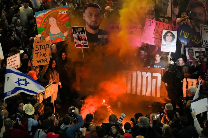 Demonstrators wave flags and signs during a protest demanding a cease-fire deal and the immediate release of hostages held in the Gaza Strip by Hamas, in Tel Aviv, Israel, Saturday, Jan. 11, 2025.