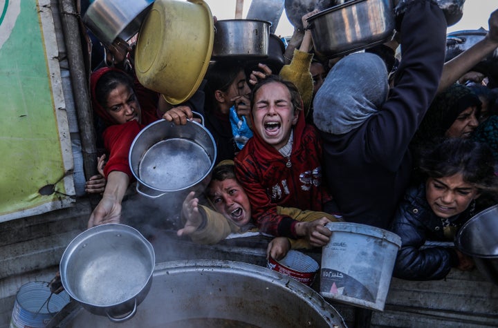 Palestinians carrying empty pots line up Jan. 2 in Khan Younis to receive meals distributed by aid organizations. People in the territory have suffered from hunger amid Israel's blockade.