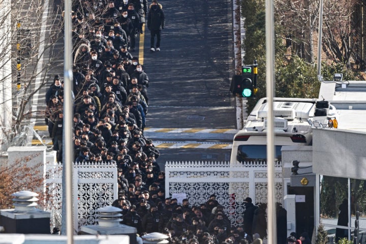 Police officers and investigators leave the residence of impeached South Korean President Yoon Suk Yeol in Seoul on January 15, 2025. After authorities entered his residence to arrest him, South Korea's impeached President Yoon Suk Yeol agreed on January 15 to appear at the office of investigators probing him over insurrection, his lawyer said. (Photo by ANTHONY WALLACE / AFP) (Photo by ANTHONY WALLACE/AFP via Getty Images)