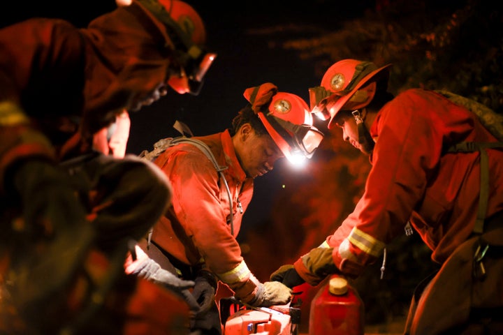 A California Department of Corrections hand crew works containment lines ahead of the Palisades Fire, on Jan. 14, 2025 in Santa Monica, Calif.