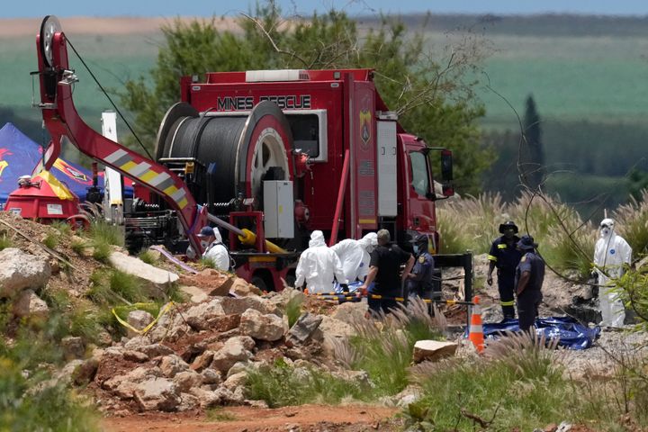 Forensic service workers carry body remains in blue body bags during a rescue operation at an abandoned gold mine in Stilfontein, South Africa, on Wednesday.