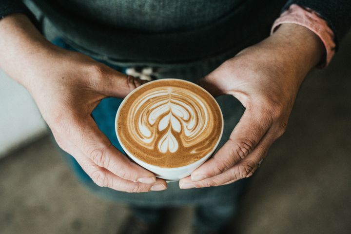 Person holding a cup of coffee.