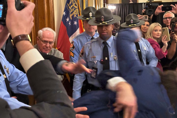 Georgia state Sen. Colton Moore, R-Trenton, falls to the floor during a shoving match outside door of the state House on Thursday, Jan. 16, 2025, before he was denied entry at the Georgia Capitol in Atlanta. (AP Photo/Jeff Amy)