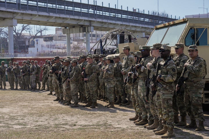 Members of the National Guard stand for Texas Gov. Greg Abbott and fellow governors as they hold a press conference along the Rio Grande at the U.S.-Mexico border to discuss Operation Lone Star and border concerns on Feb. 4, 2024, in Eagle Pass, Texas. 