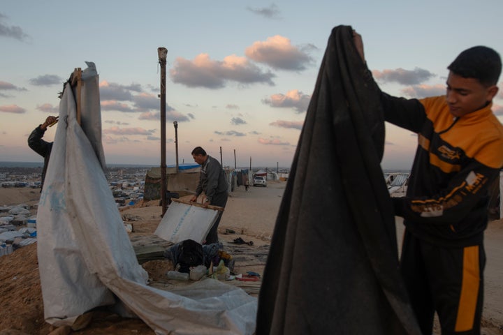 Warga Palestina membangun tenda di kamp Mawasi di Khan Younis, Jalur Gaza tengah, Sabtu 18 Januari 2025.(AP Photo/(AP Photo/Jehad Alshrafi)