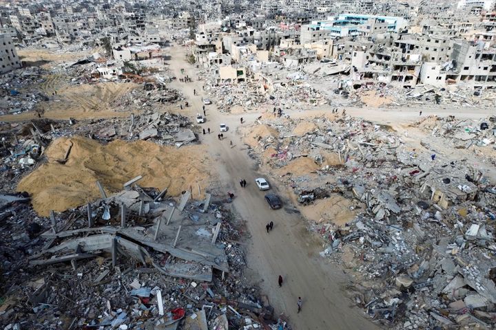 Palestinians walk through the destruction by the Israeli air and ground offensive in Rafah, as a ceasefire deal between Israel and Hamas went into effect Sunday, Jan. 19, 2025. (AP Photo/Jehad Alshrafi)