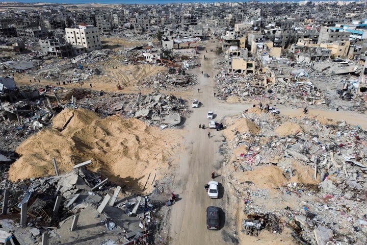 Palestinians walk through the destruction left by Israeli forces in Rafah, as a ceasefire deal between Israel and Hamas went into effect Sunday, Jan. 19, 2025.