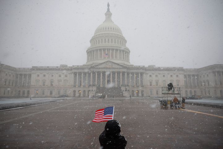 An American flag is held in the snow outside the U.S. Capitol Building on January 19, 2025 in Washington, DC. . (Photo by Kevin Dietsch/Getty Images)