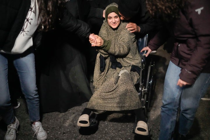 A female Palestinian prisoner on a wheelchair is greeted after disembarking from a bus following her release from an Israeli prison, in the West Bank city of Beitunia, early Monday, Jan. 20, 2025. (AP Photo/Leo Correa)