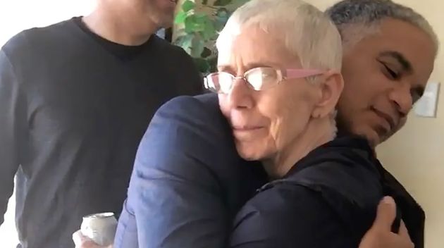 The author hugging his mother as he greets her at the entrance of her home in West Baltimore. His brother, Patrick, stands behind him.