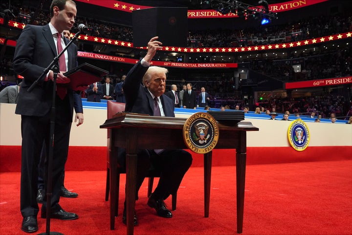 President Donald Trump holds up an executive order he signed as he attends an indoor Presidential Inauguration parade event at Capital One Arena on Jan. 20 in Washington.