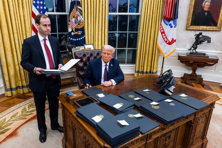 President Donald Trump signs executive orders in the Oval Office of the White House in Washington on Monday.