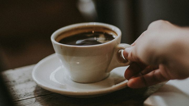 Hand holding a cup of coffee