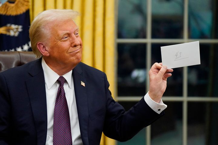 President Donald Trump holds up a letter from President Joe Biden at the White House on Jan. 20, 2025. 