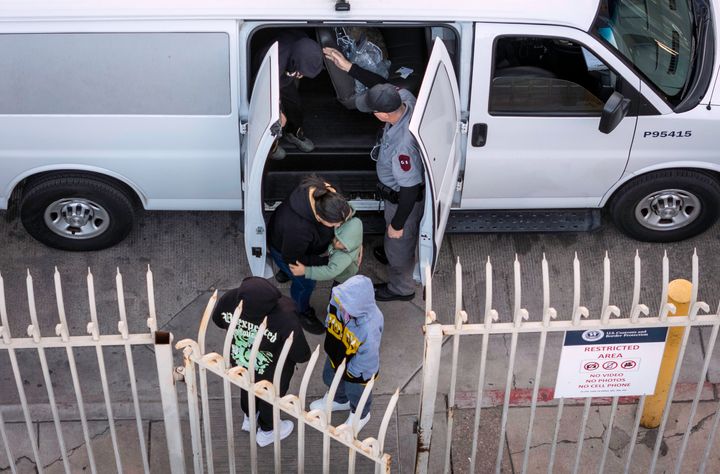 In this aerial view, deportees unload from a Customs and Border Protection transport vehicle before being sent back to Mexico on Jan. 22 in Nogales, Arizona. Trump signed executive orders on his first day in office declaring a state of emergency at the U.S. southern border, halting asylum claims and launching a campaign of mass deportations.