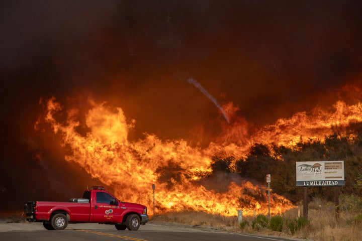 A firefighter truck backs up from flames of smoke from the new Hughes Fire at the Lake Hughes Road in Castaic, a northwestern neighborhood of Los Angeles, California, on January 22, 2025.