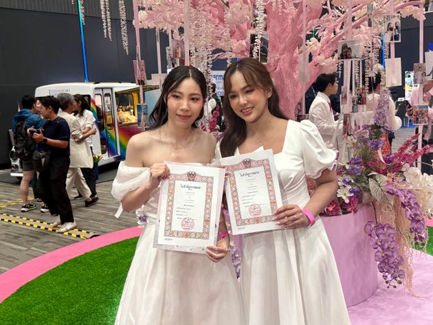 サイアム・パラゴンで開かれた合同結婚イベントで、婚姻証明書を見せるカップル（2025年1月23日）