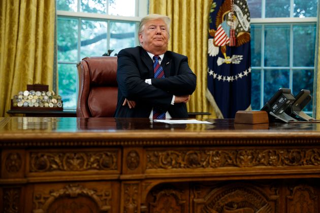 President Donald Trump crosses his arms 