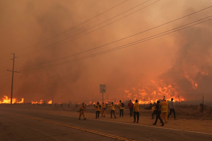 Firefighters monitor flames caused by the Hughes Fire along Castaic Lake in Castaic, Calif., Wednesday, Jan. 22, 2025. (AP Photo/Marcio Jose Sanchez)