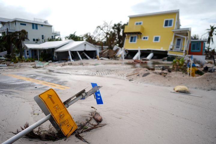 A house sits toppled off its stilts after the passage of Hurricane Milton, alongside an empty lot where a home was swept away by Hurricane Helene, in Bradenton Beach on Anna Maria Island, Florida, in October 2024.