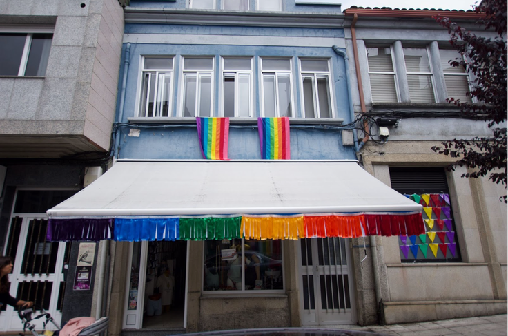 Rainbow flags hang from the haberdashery’s façade — a colorful defiance against the otherwise somber weather.