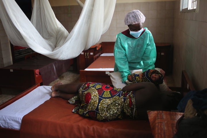 Midwife Maima Johnson hands a newborn girl to mother Cecelia Mensah, 20, after delivering the child at the Star of the Sea Health Center on January 29, 2015, in the West Point township of Monrovia, Liberia. Midwives and health workers in the clinic had taken extra precautions throughout Liberia's Ebola epidemic to avoid becoming infected.