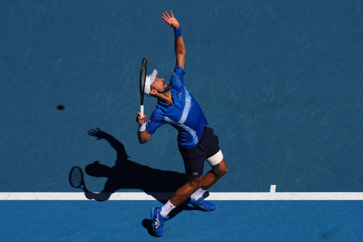 Novak Djokovic of Serbia serves to Alexander Zverev of Germany during their semifinal match at the Australian Open tennis championship in Melbourne, Australia, Friday, Jan. 24, 2025. (AP Photo/Vincent Thian)