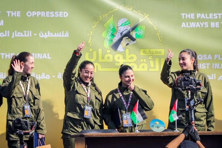 Israeli soldier hostages Naama Levy, Daniella Gilboa, Karina Ariev and Liri Albag, in no particular order, salute a Palestinian crowd before being handed over to the Red Cross in Gaza City, Saturday, Jan. 25, 2025. (AP Photo/Abed Hajjar)